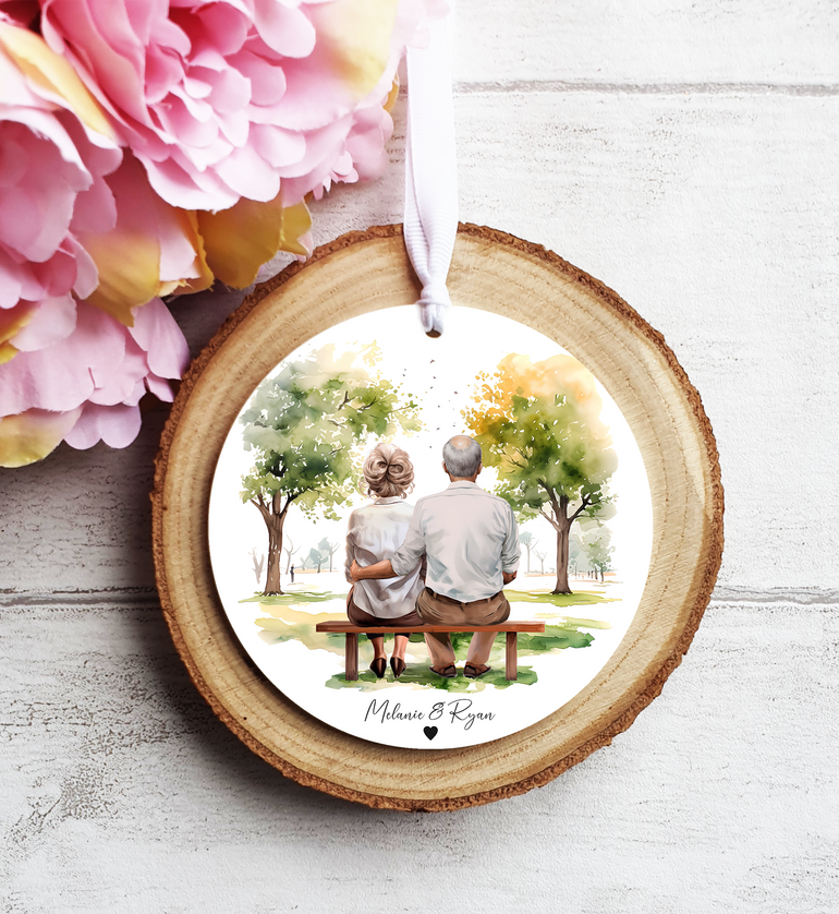 Older Couple Sitting on Bench Portrait Hanging Ornament with Green Trees Scenery